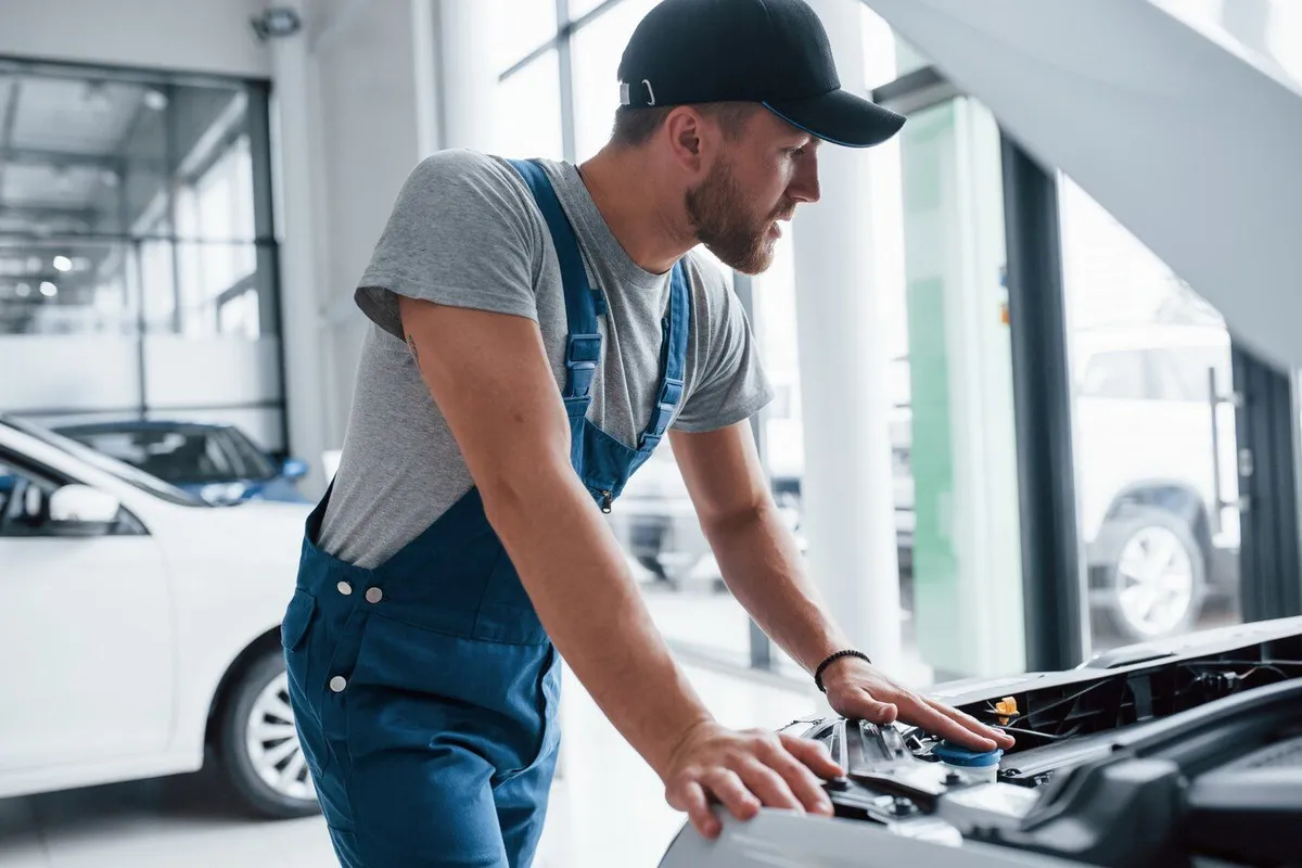 this is simple task that guy man blue uniform black hat repairing damaged automobile 146671 16089