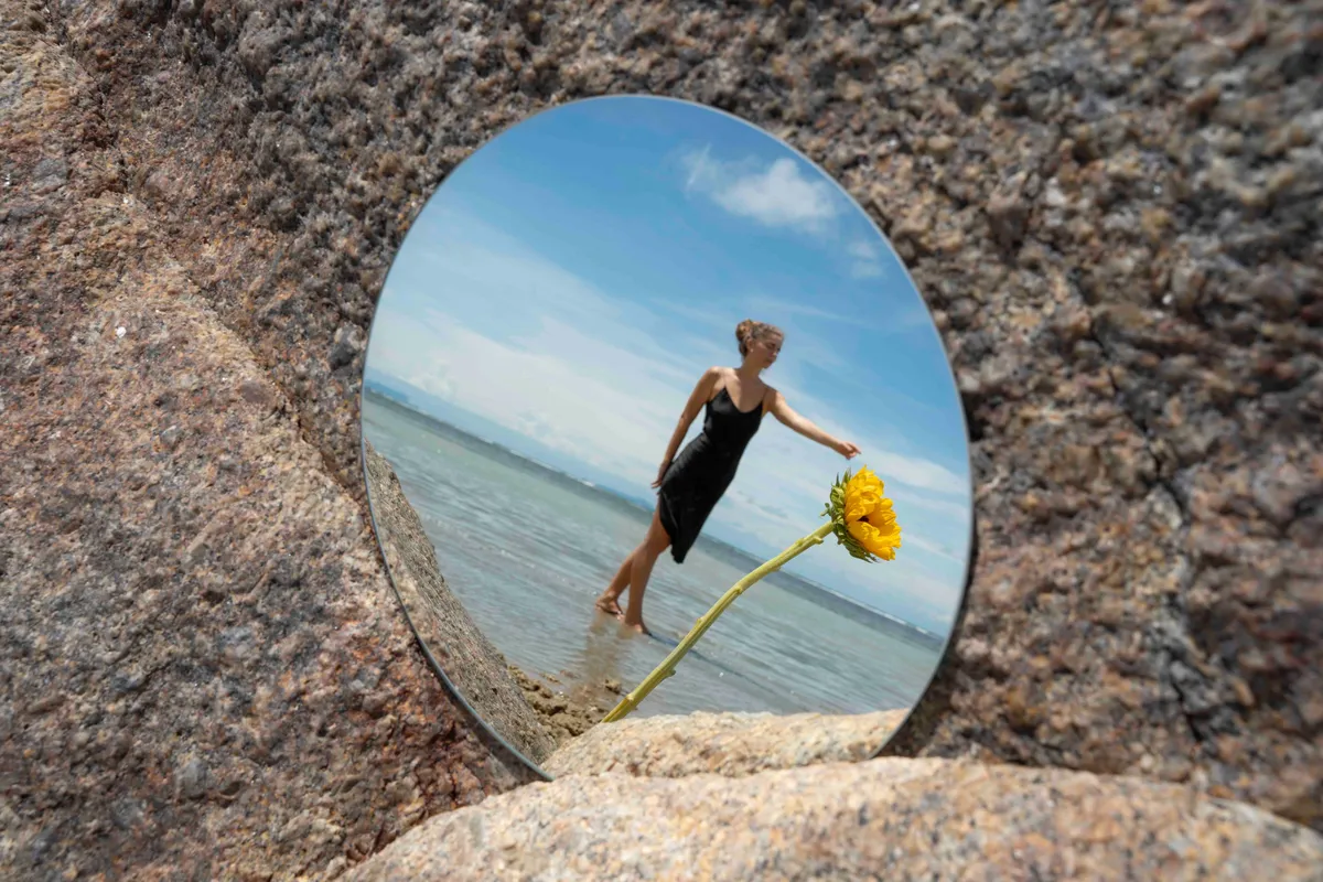 woman posing with round mirror flower