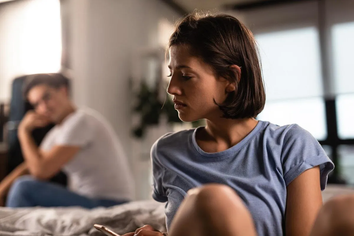 unhappy woman texting cell phone after argument with her boyfriend home man is background 637285 1597