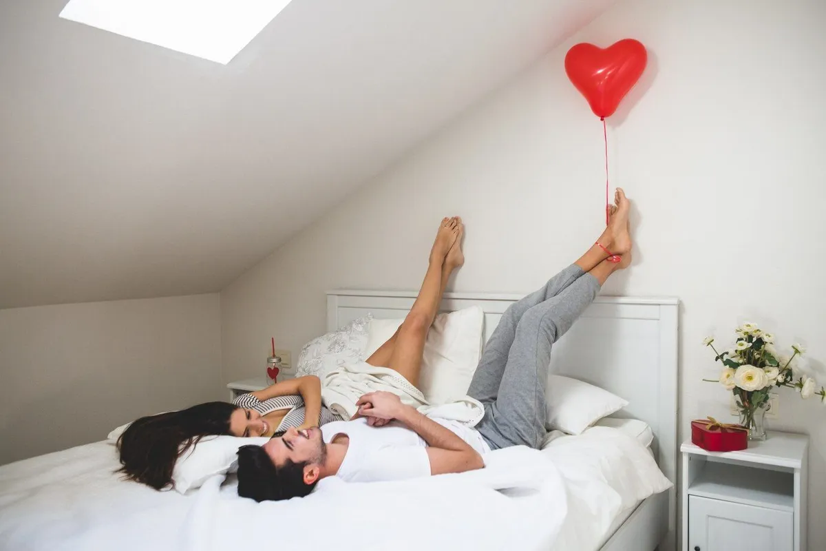 man holding heart shaped balloon with his feet 23 2147596017