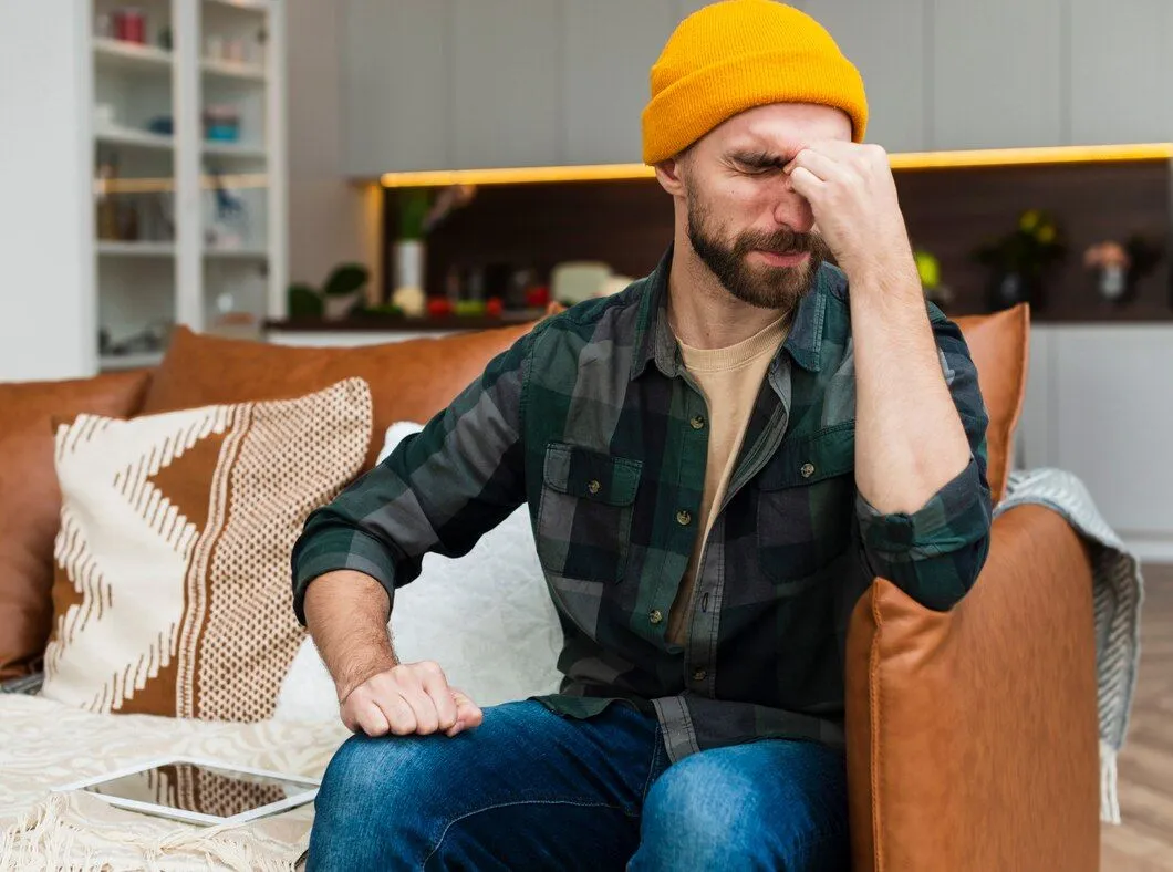 man sitting sofa having headache 23 2148363638
