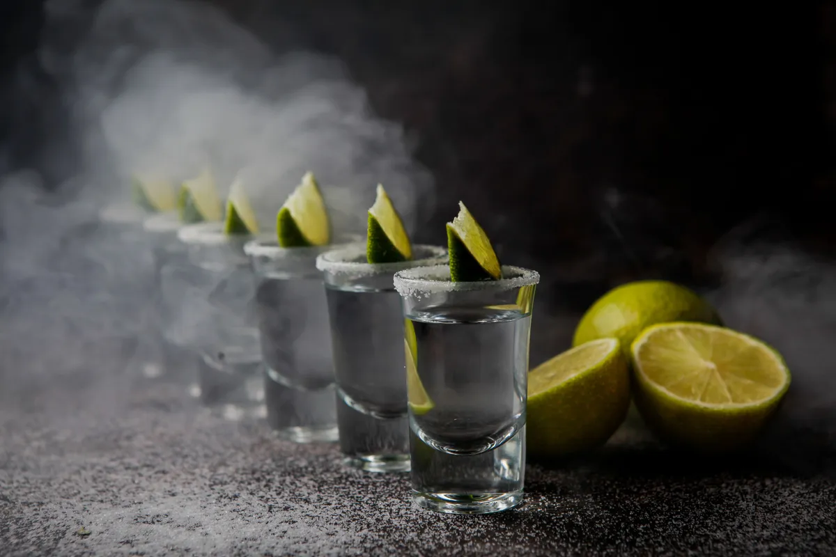side view tequila glass served with limes salt