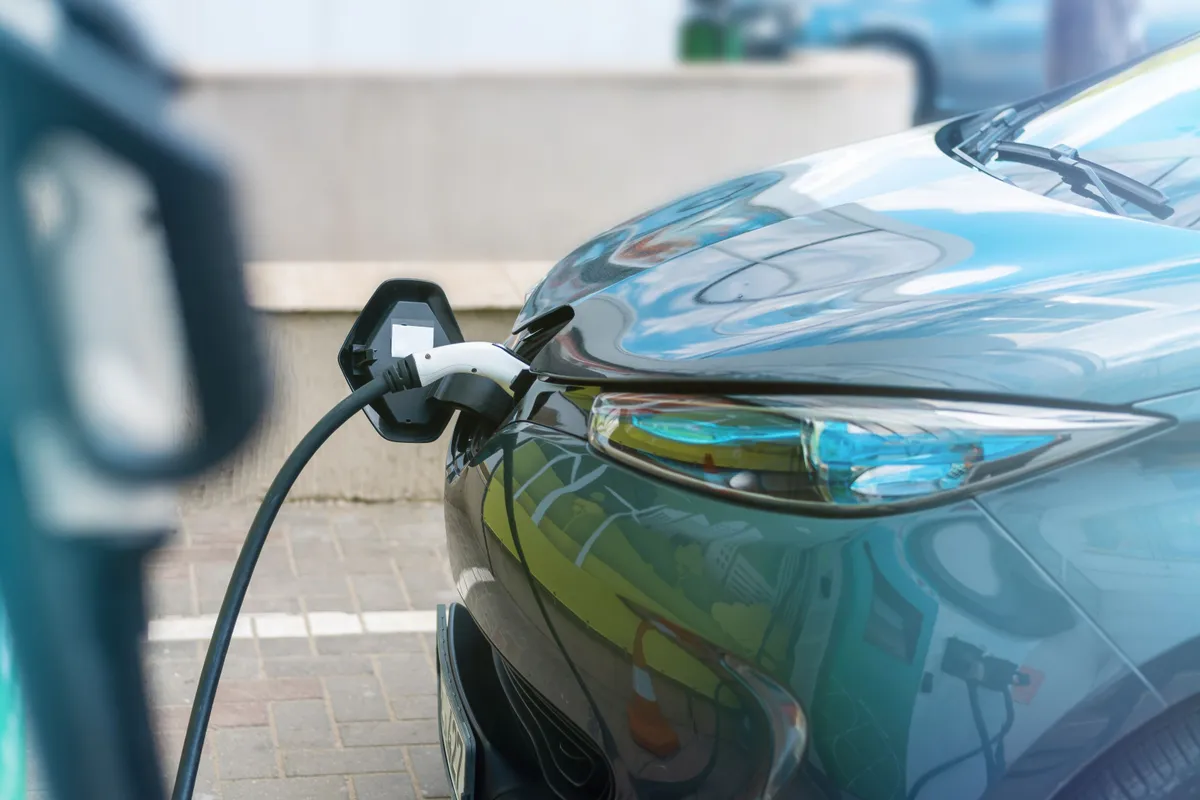 plugged charger into electric car charge station