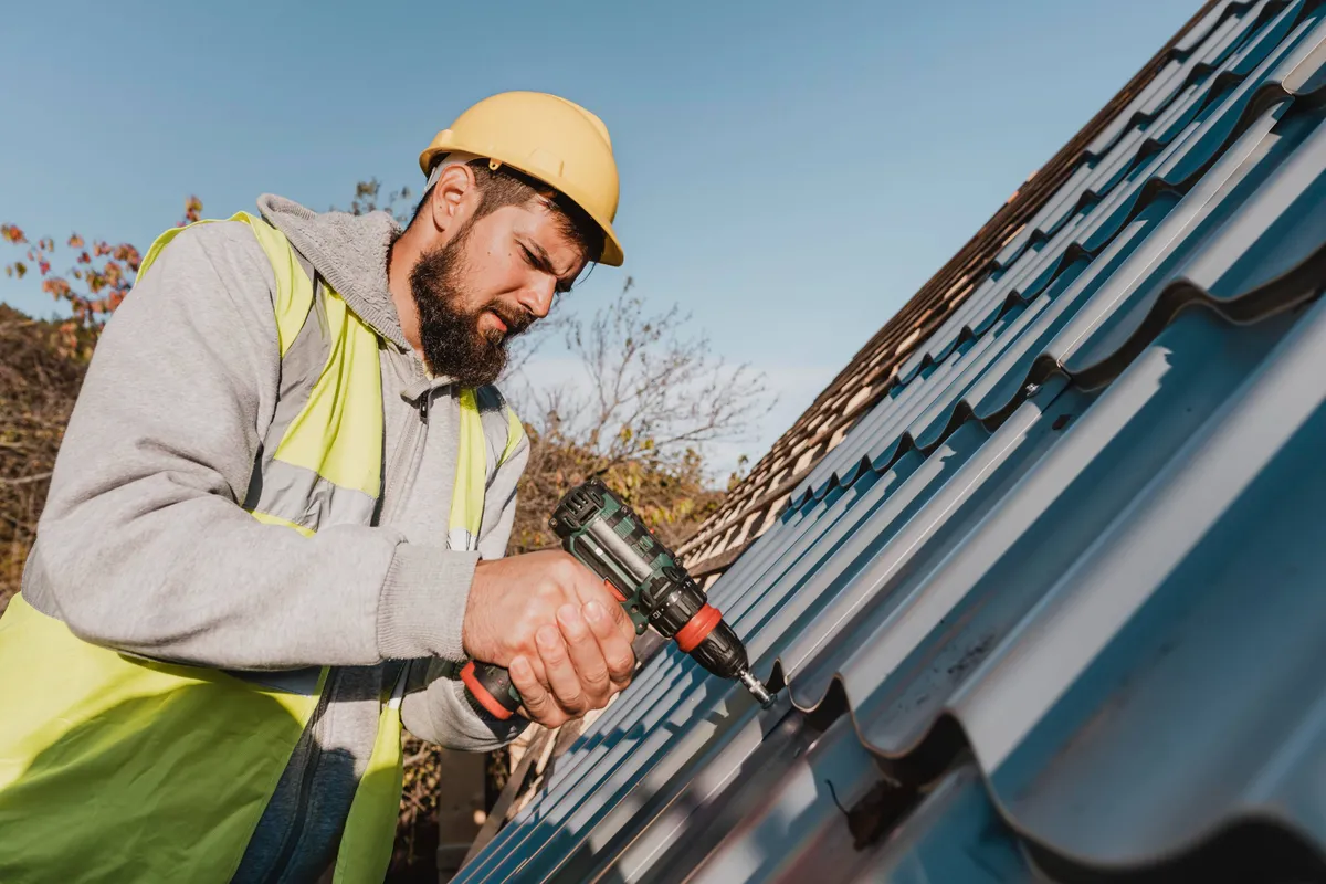 sideways man working roof with drill