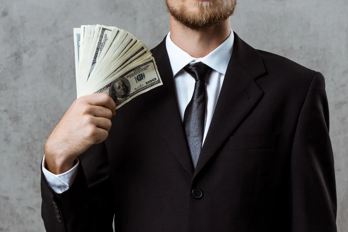 young successful businessman suit holding money