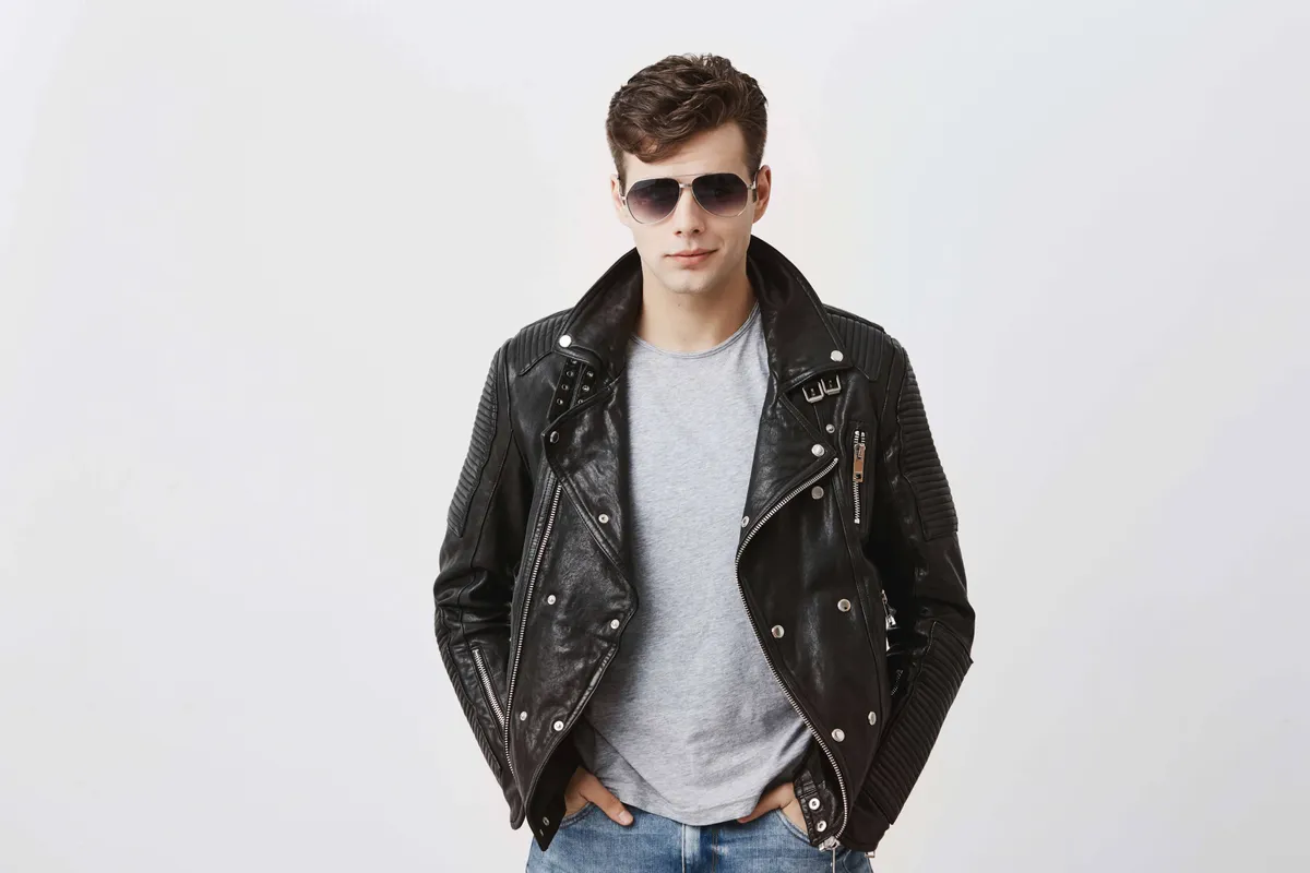 confident serious handsome man wears black leather jacket gray t shirt stylish eyewear looks directly into camera isolated people style concept