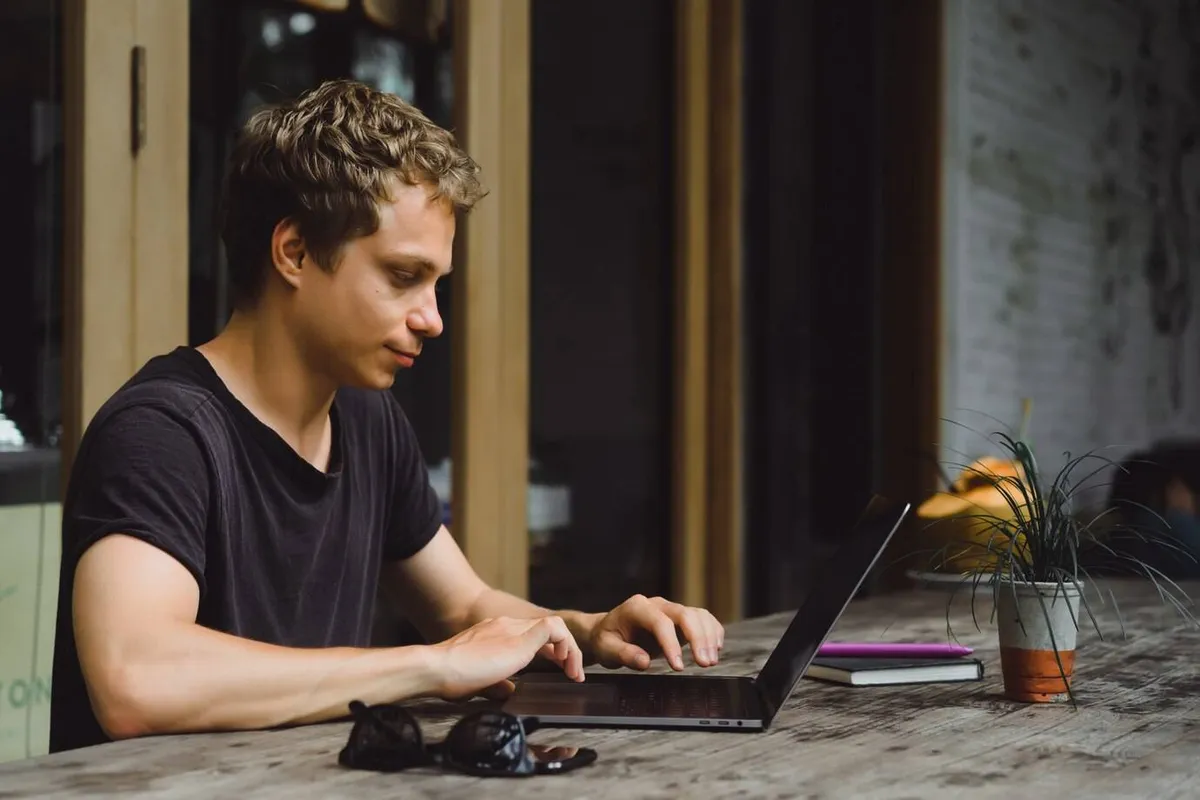 man working with laptop cafe wooden table 1321 797