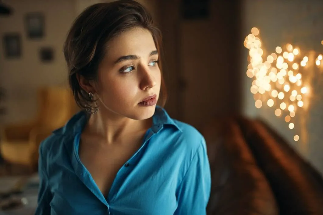 portrait attractive young caucasian woman with gathered hair posing stylish apartment with blurred lights background having upset bored facial expression 343059 2098