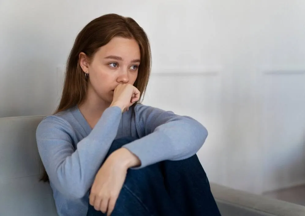 side view worried woman sitting couch 23 2149450376