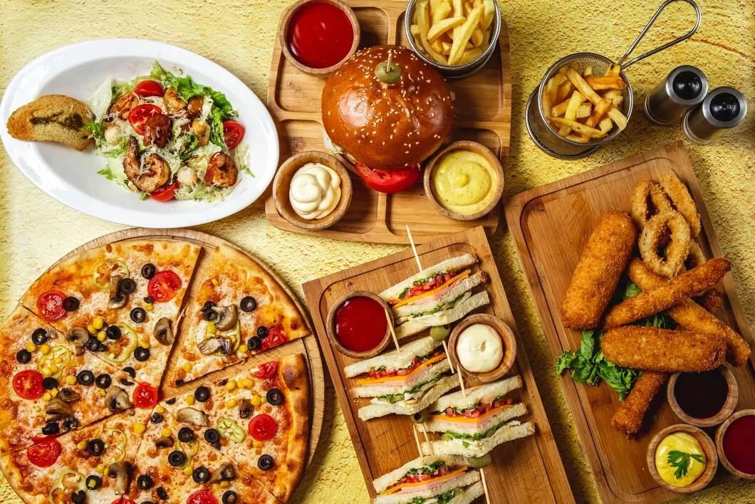 top view fast food mix mozzarella sticks club sandwich hamburger mushroom pizza caesar shrimp salad french fries ketchup mayo cheese sauces table 141793 3998