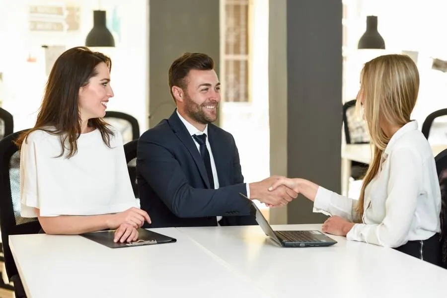 smiling young couple shaking hands with insurance agent 1139 978 1