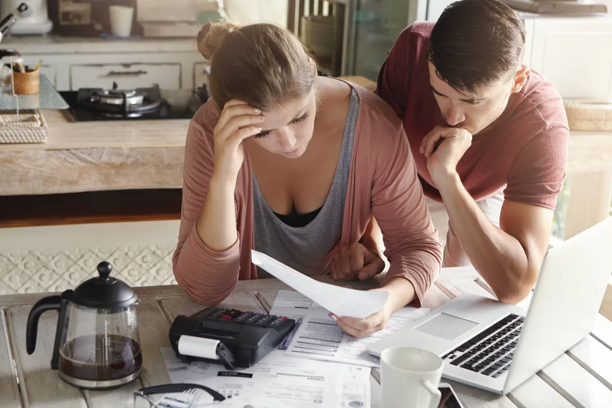 worried couple reviewing their family finances calculating expenses