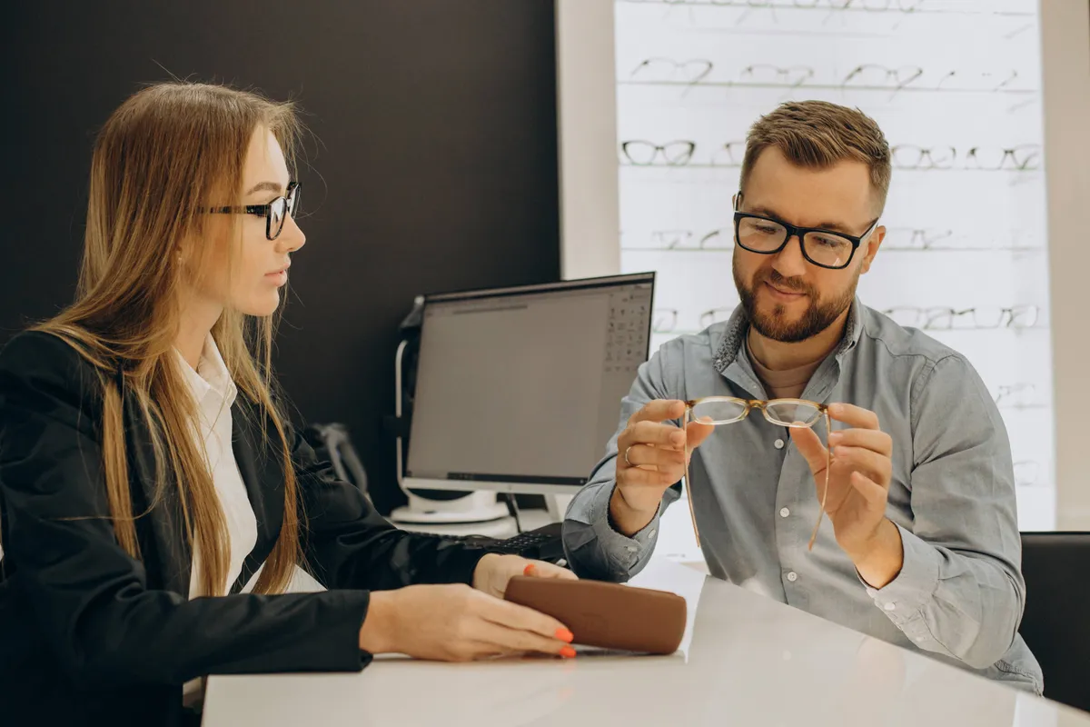 customer-shoosing-spectacles-optic-store-with-help-sales-person