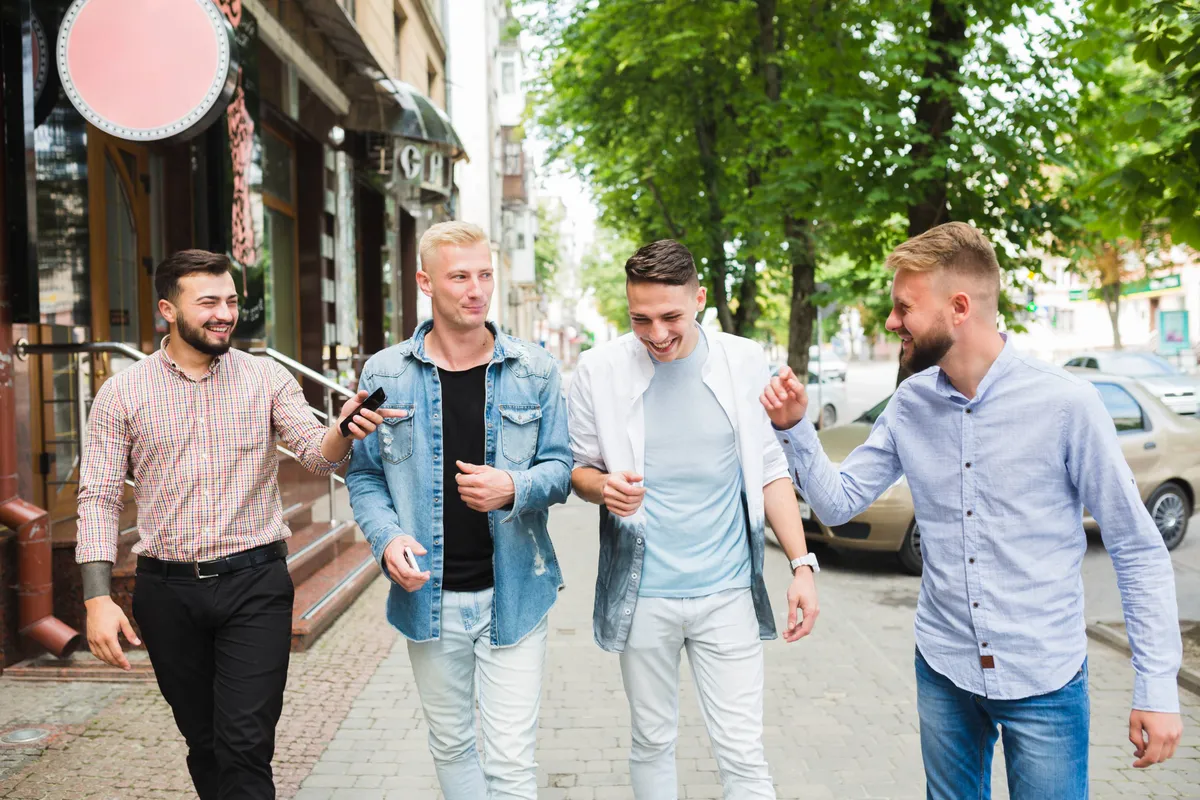 male-friends-walking-together-city-street-enjoying