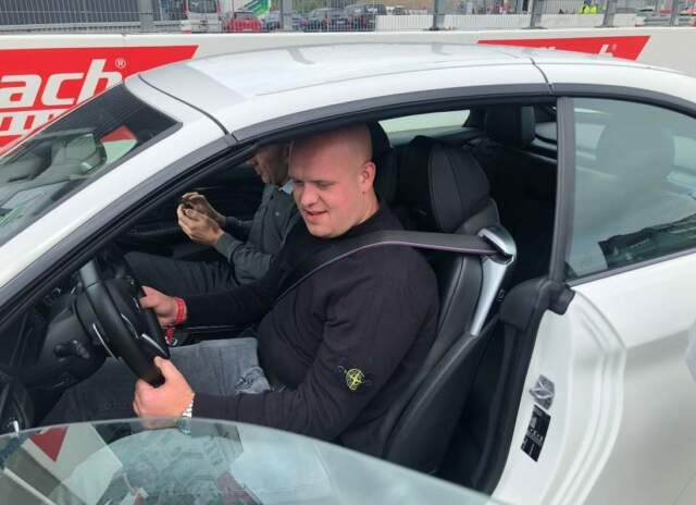 Michael van Gerwen neemt plaats achter het stuur van een raceauto