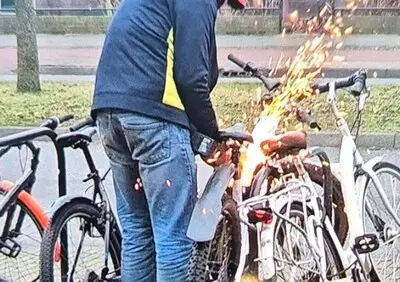 Dief slijpt slot van elektrische fiets met slijptol terwijl getuige hem filmt