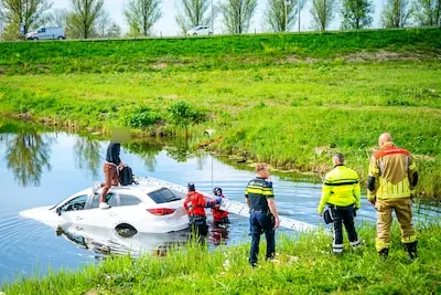 Man raakt met auto te water langs N11, maar klimt dan snel op het dak