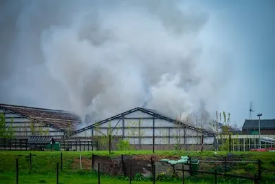 Grote brand in schuur in Boskoop, brandweer probeert andere loodsen te redden