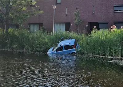 Auto schiet van de weg en belandt in vijver in Tilburg