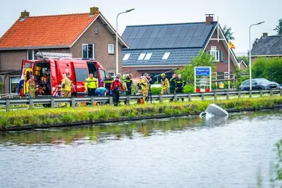 Auto rijdt water in langs Westkanaalweg in Ter Aar