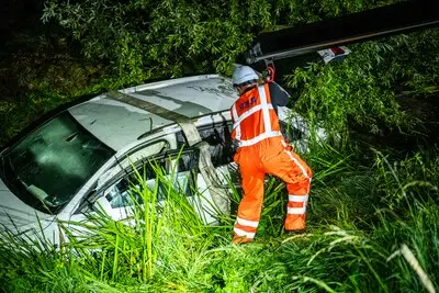 Auto rijdt sloot in na botsing met lantaarnpaal in Alphen aan den Rijn