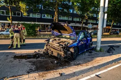 Bestuurder botst op hoge snelheid tegen stoeprand en rijdt daarna twee palen omver in Eindhoven, auto total loss