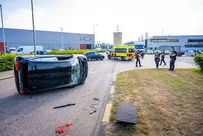 Auto op zijn kant na botsing op bedrijventerrein in Alphen