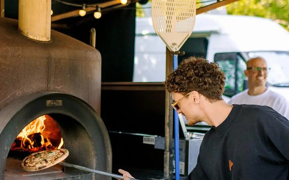 Davidè (30) en Ron (37) uit Groningen bakken houtgestookte pizza’s op allerlei events:  ‘Met Paradigm en Noorderzon kunnen we gewoon op het fietsje heen en weer, héérlijk!’