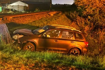 Auto botst tegen hek langs spoor in Boskoop