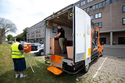 In oranje busje jongeren opzoeken in de Eindhovense wijken