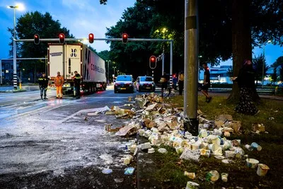 Vrachtwagen verliest lading zuivel op kruising in Tilburg, omstanders slaan slag
