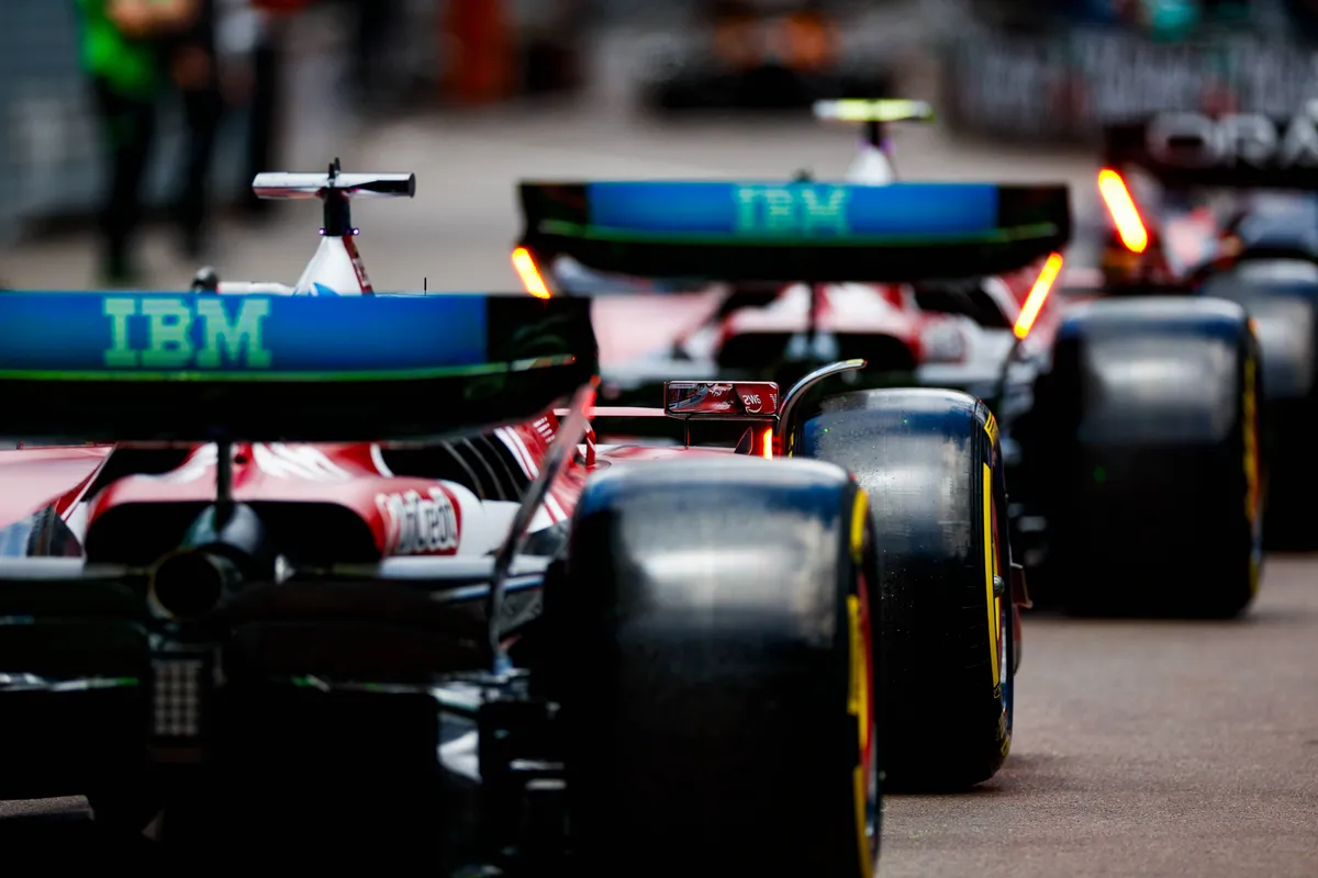 De achtervleugels van de Ferrari-bolides van Leclerc en Hamilton in de pitstraat in Monaco