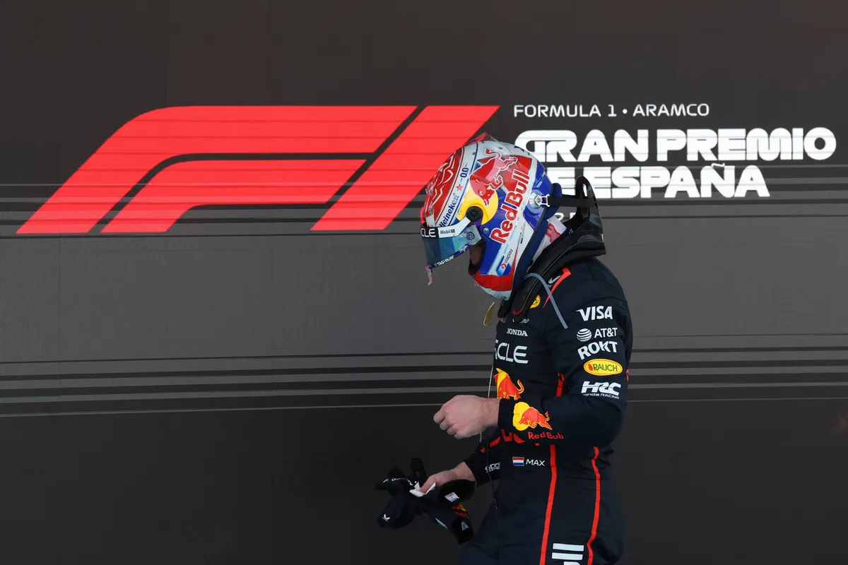 Max Verstappen loopt met gebogen hoofd terug naar de paddock na een tegenvallend einde van de race in Barcelona