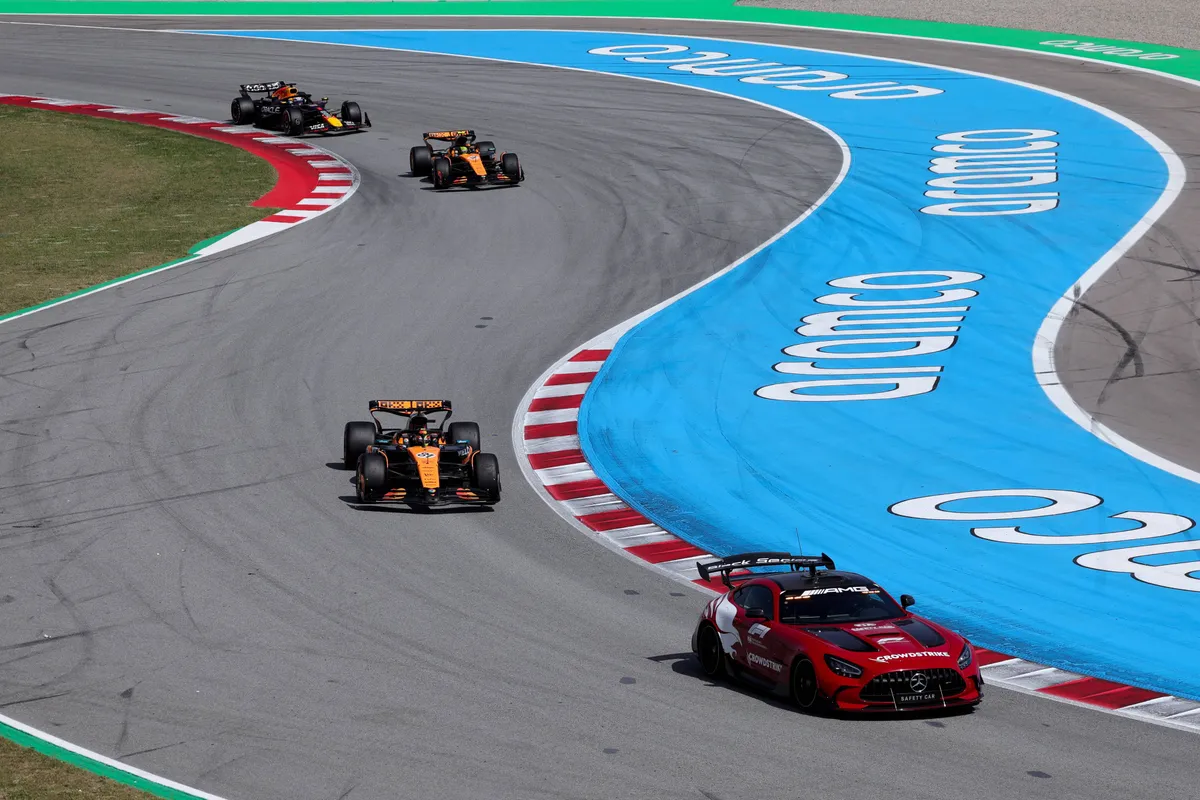 De safety car is op de baan in Barcelona, met Oscar Piastri, Lando Norris en Max Verstappen daarachter