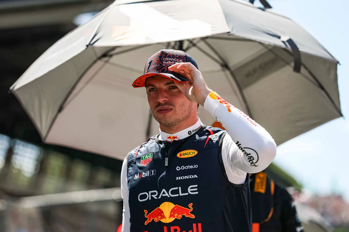 Max Verstappen schuilt voor de zon op de grid in Oostenrijk