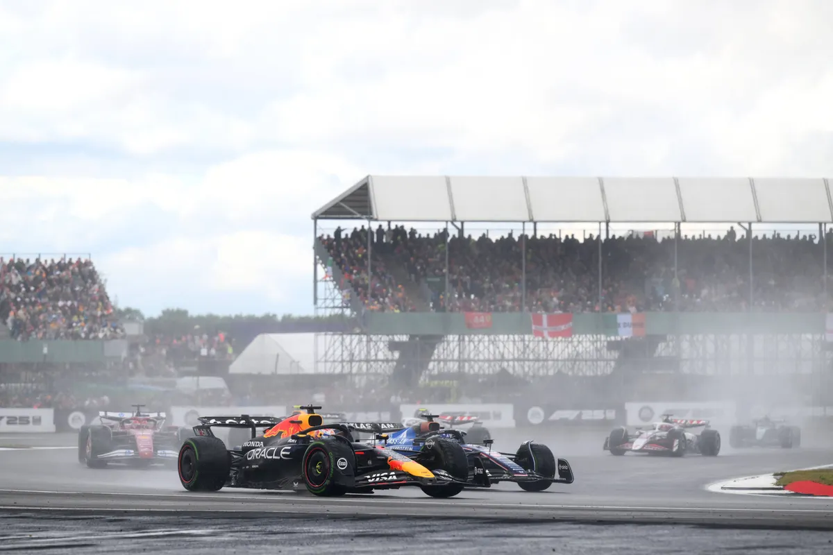 Max Verstappen in de regen in Silverstone na zijn spin met een Williams op de achtergrond