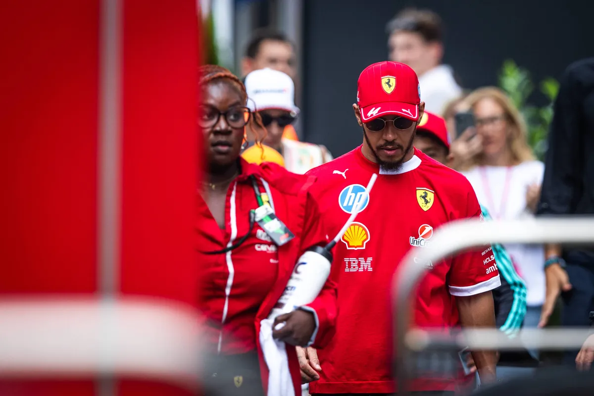 Ferrari-coureur Lewis Hamilton loopt met de persmanager van Ferrari door de F1-paddock in Hongarije
