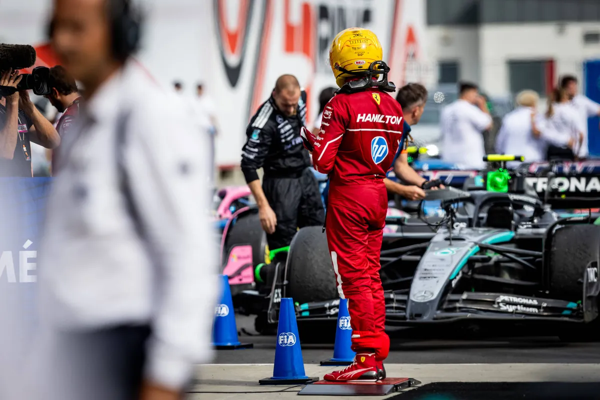 Ferrari-coureur Lewis Hamilton kijkt teleurgesteld naar de Mercedes-auto na de race in Hongarije