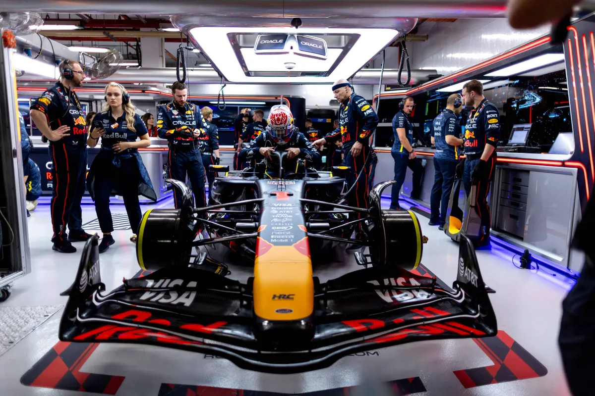 Max Verstappen in zijn Red Bull RB21, omringd door zijn monteurs, in de Red Bull-garage