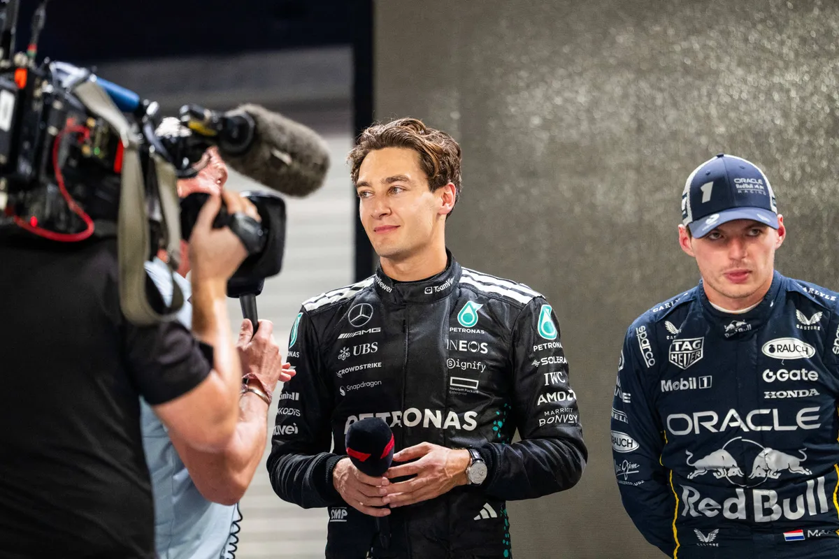 Max Verstappen luistert naar het interview van George Russell na de Grand Prix van Singapore in 2025