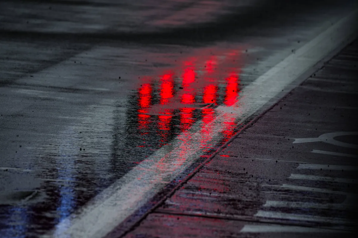 De startlampen reflecteren in het water in de pitstraat in Silverstone in 2025