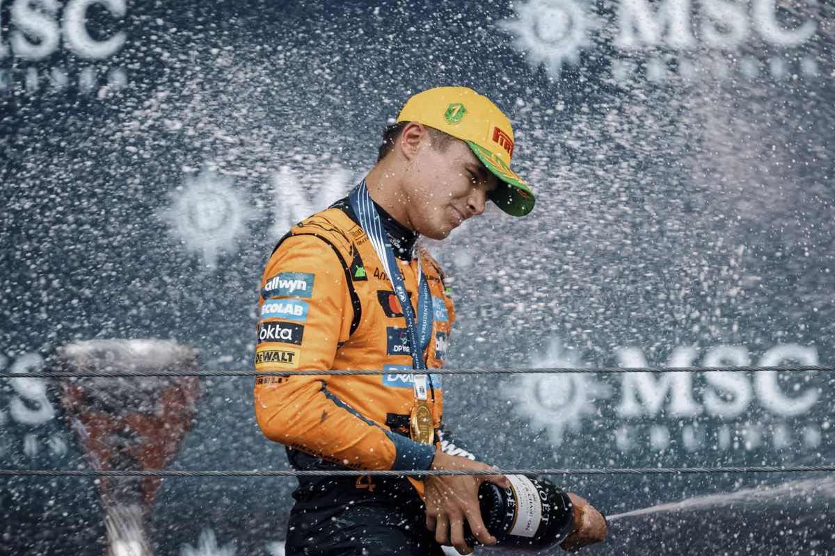 McLaren-coureur Lando Norris sprayt champagne op het podium in Brazilië