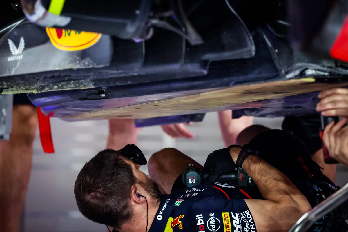 Red Bull-monteur voert werk uit op de vloer van de Red Bull-auto van Max Verstappen