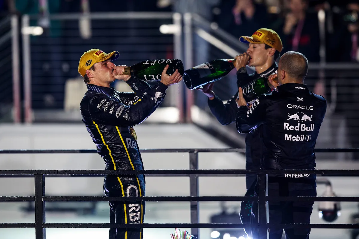 Max Verstappen drinkt champagne na de race in Las Vegas met race-engineer Gianpiero Lambiase en Mercedes-coureur George Russell