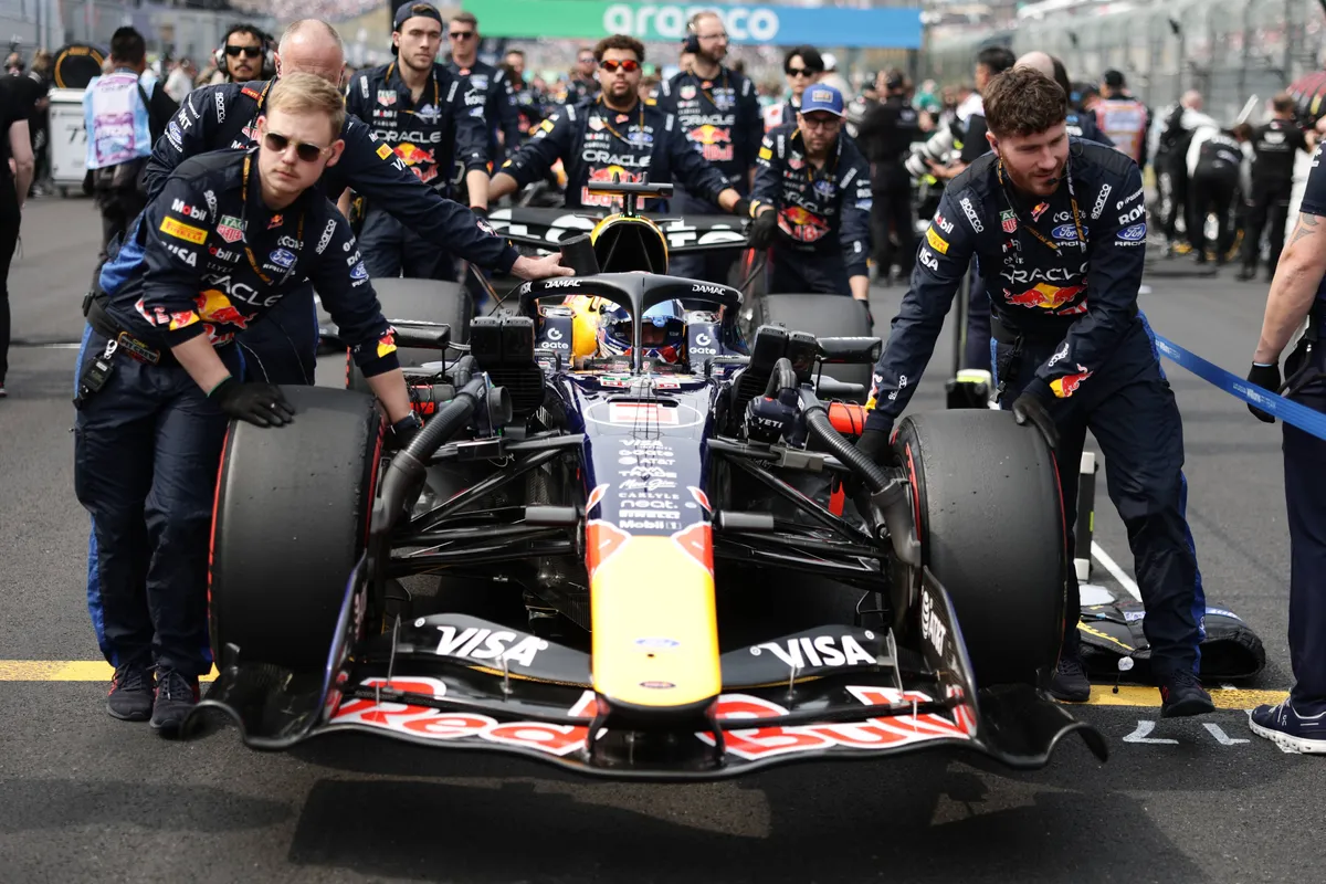 Red Bull-coureur Max Verstappen wordt door zijn monteurs de grid op geduwd in Japan 2026