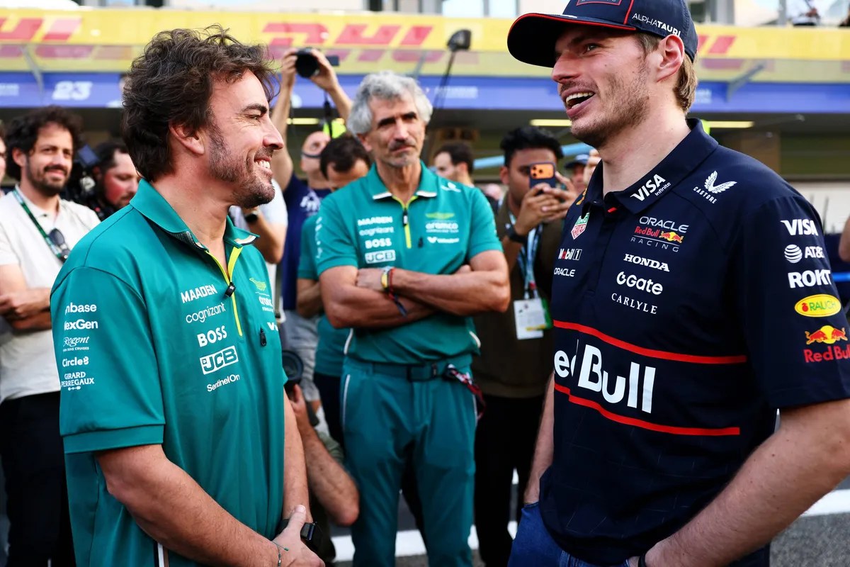 Max Verstappen en Fernando Alonso praten met elkaar in de F1-pitstraat in Abu Dhabi in 2025