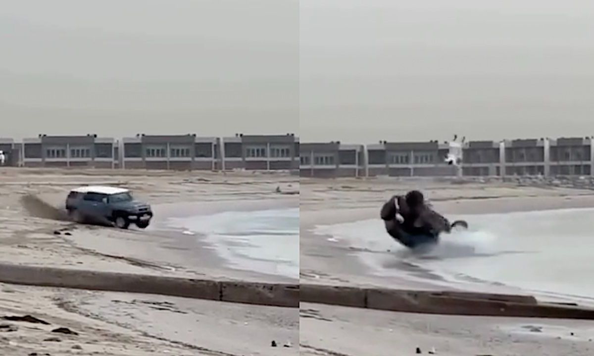 Man doet stoer met auto op strand, eindigt huilend in zee