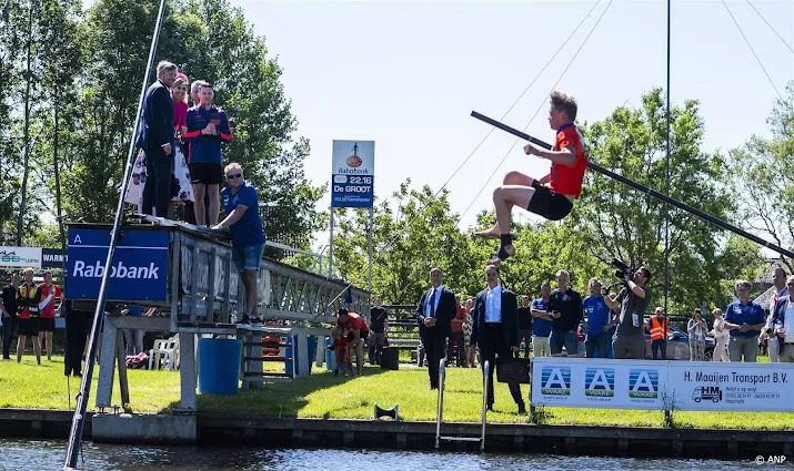 Koningspaar geniet van demonstratie polsstokverspringen