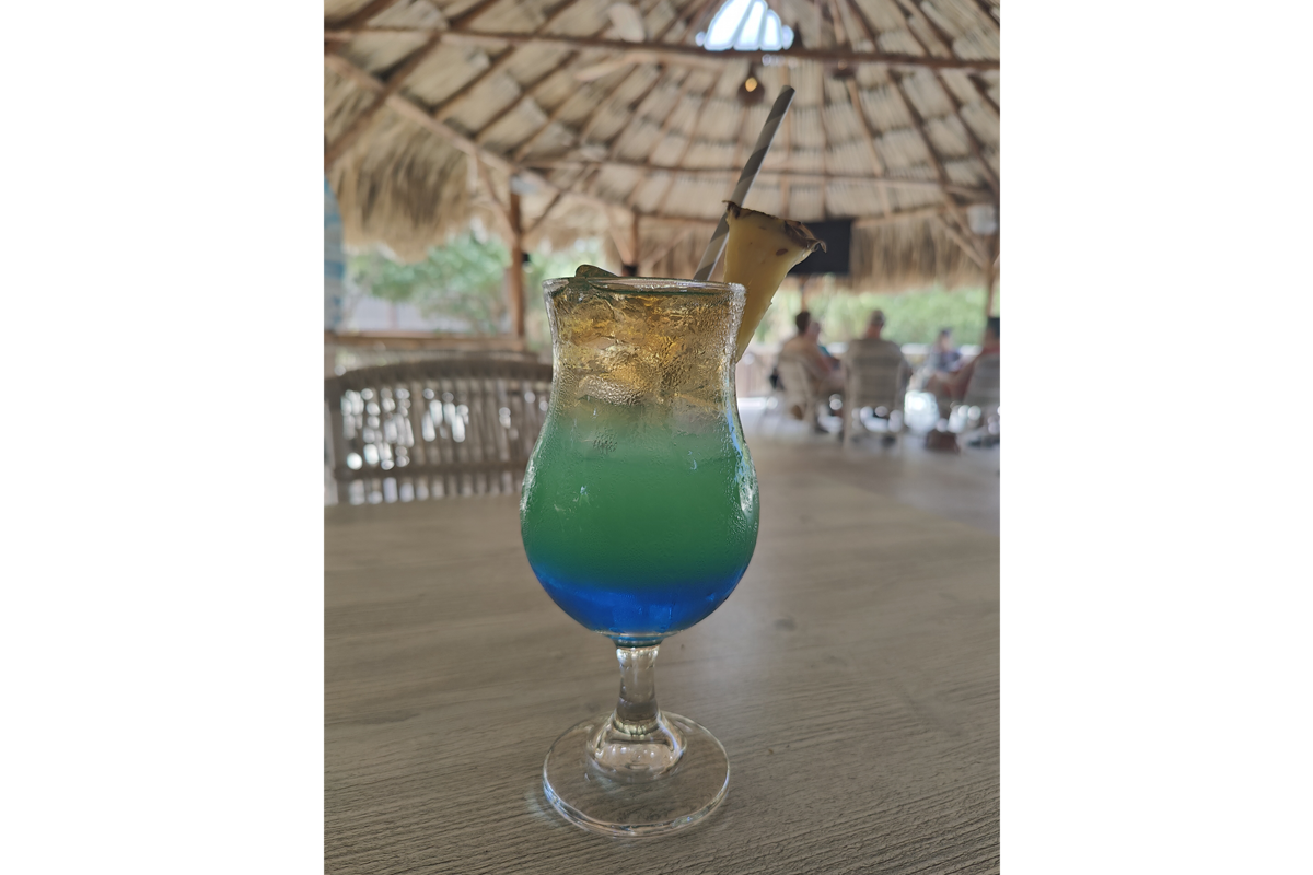 Deze foto is qua achtergrond en ondergrond zodanig dezelfde kleuren, dat de blauwe drank er extra goed op uitkomt. Had de tafel volgelegen met troepjes, dan was dat een stuk moeilijker geworden.