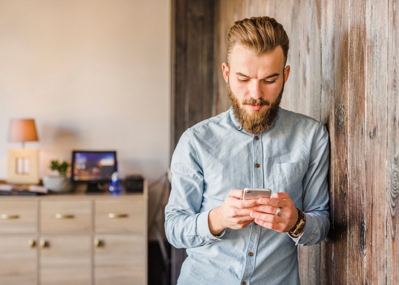 bearded young man using cellphone home 23 2147955392